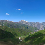 Widok na zieloną dolinę i wysokie góry podczas trekkingu w Uzbekistanie