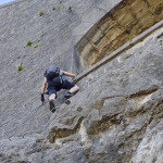 Wspinacz na via ferracie pod kamiennymi murami twierdzy Bastille w Grenoble