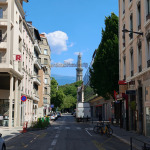 Ulica w Grenoble z zabudową centrum miasta i Tour Perret widoczną w oddali
