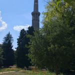 Tour Perret w Grenoble widziana spomiędzy drzew podczas trwającego remontu obiektu