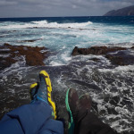 Odpoczynek na czarnych skałach nad wzburzonym oceanem w Ponta do Sol na Santo Antão