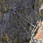 Przejście eksponowanym mostkiem linowym na via ferracie Des 3 Fontaines w Chamrousse
