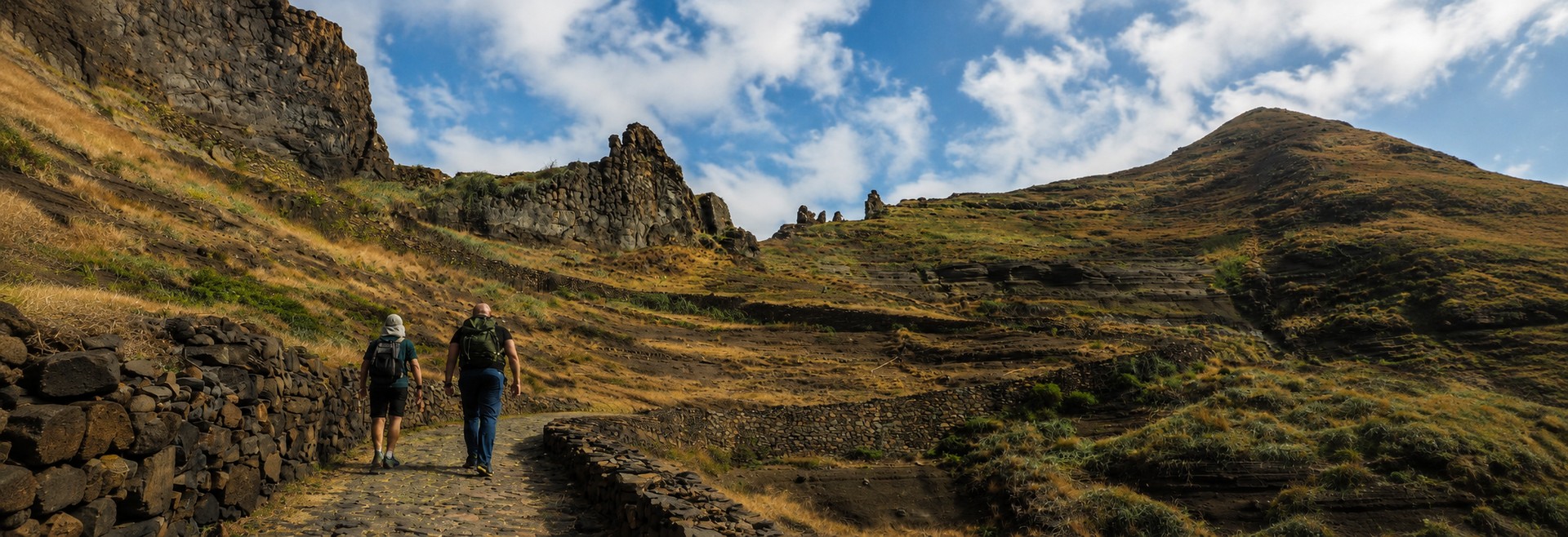 Santo Antão trekking – turyści idą kamiennym szlakiem wśród skalistych zboczy na wyspie Santo Antão, Wyspy Zielonego Przylądka