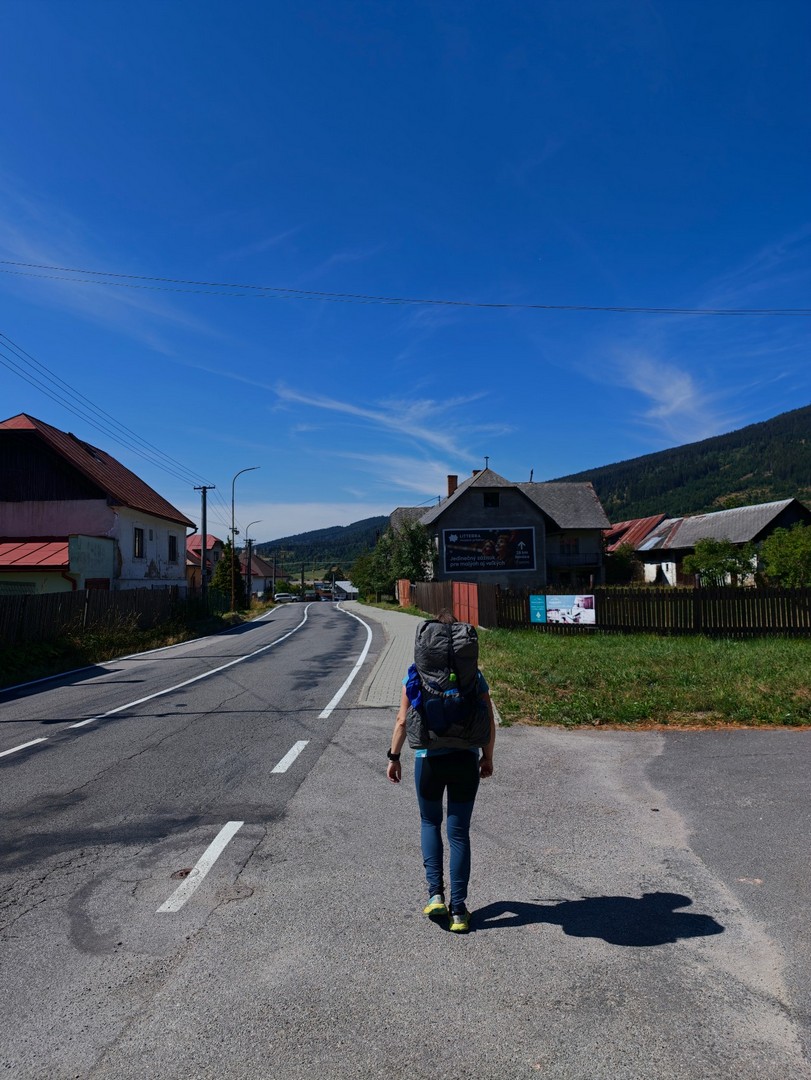 Turystka z plecakiem opuszcza Telgárt na początku trekkingu w Niżnych Tatrach 