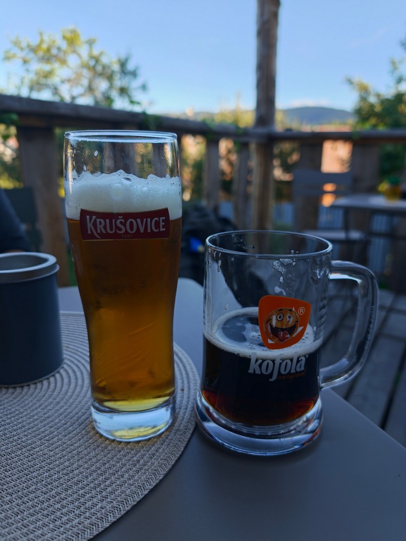 Szklanka piwa i kufel Kofoli ustawione na stole na zadaszonym tarasie