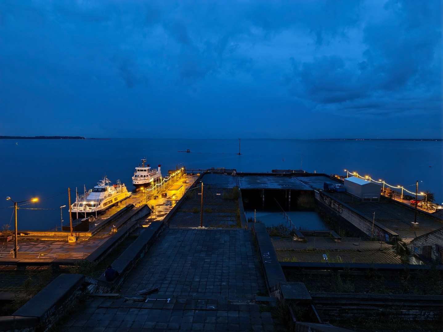 Widok z Linnahall na port w Tallinnie, zacumowane statki i Morze Bałtyckie wieczorem