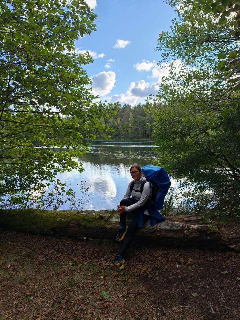 Turystka odpoczywająca nad brzegiem jeziora Paukjärv podczas trekkingu szlakiem Oandu–Aegviidu–Ikla