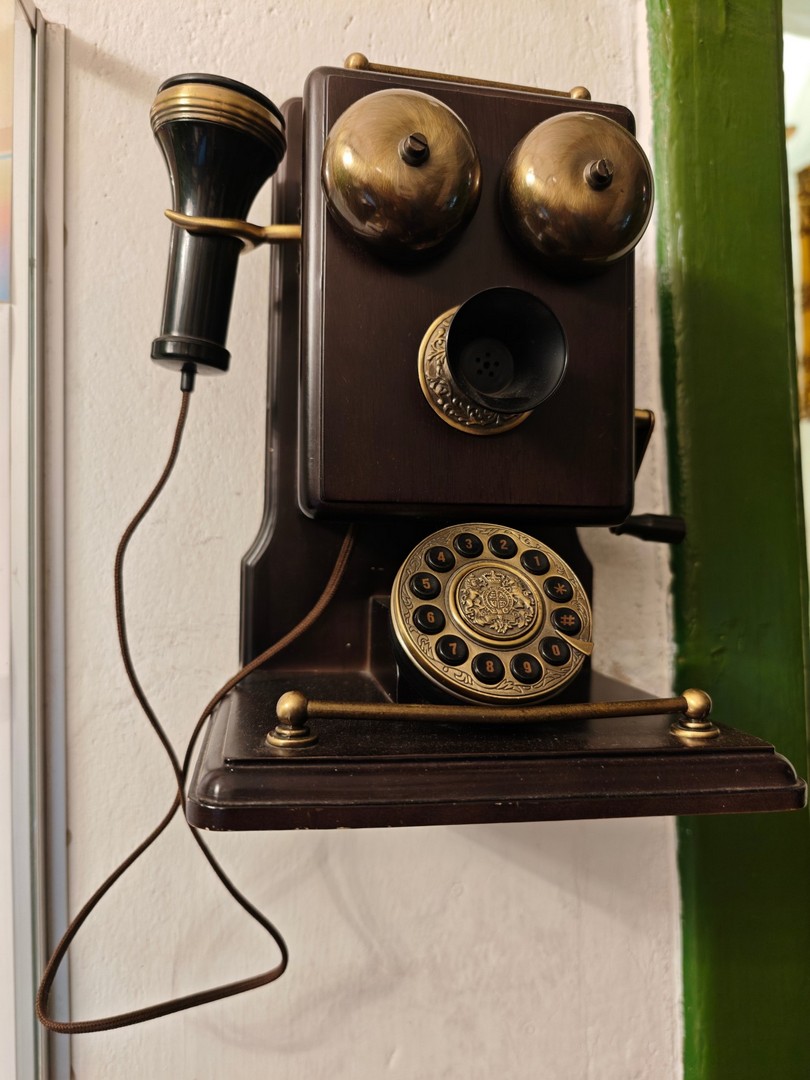 Zabytkowy telefon ścienny z tarczą numeryczną w hotelu St. Olav na Starym Mieście w Tallinnie