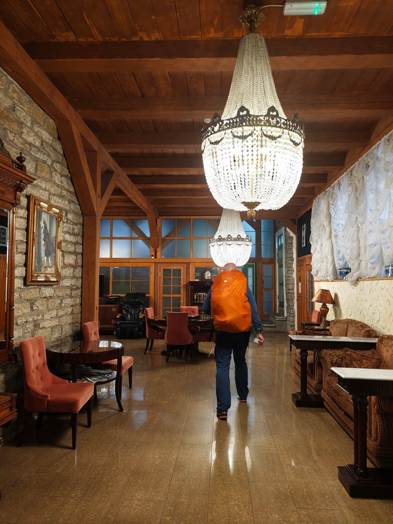 Historyczne wnętrze hotelu St. Olav w Tallinnie z kamiennymi ścianami, drewnianym stropem i kryształowymi żyrandolami